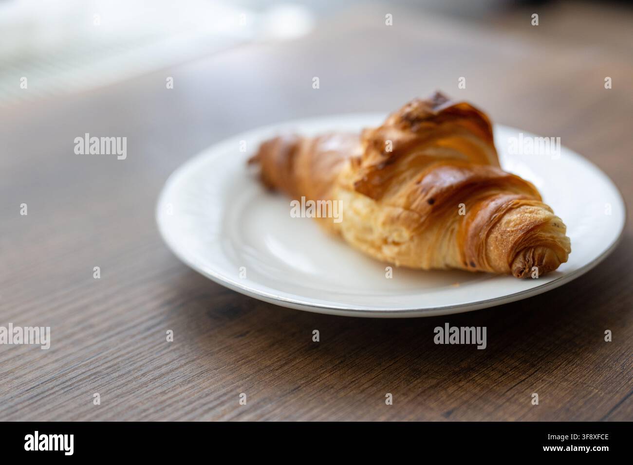 Französisches Croissant gefüllt mit reichhaltiger, zart schmelzender Schokoladencreme. Weiche Studiolichtbeleuchtung betont die zarten, blättrigen Teigschichten, knusprig buttrig Stockfoto