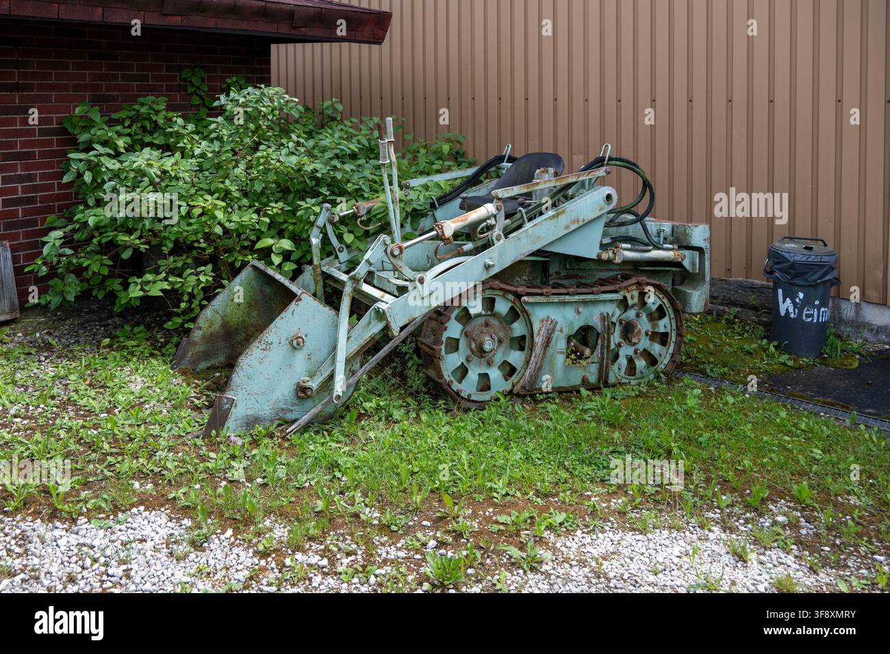 Eschach, Deutschland 27. Jul 25: Kleiner Vintage-Kettenlader mit verrosteter Schaufel im Freien im Schwäbischen Bauern- und Technikmuseum in Seifert Stockfoto