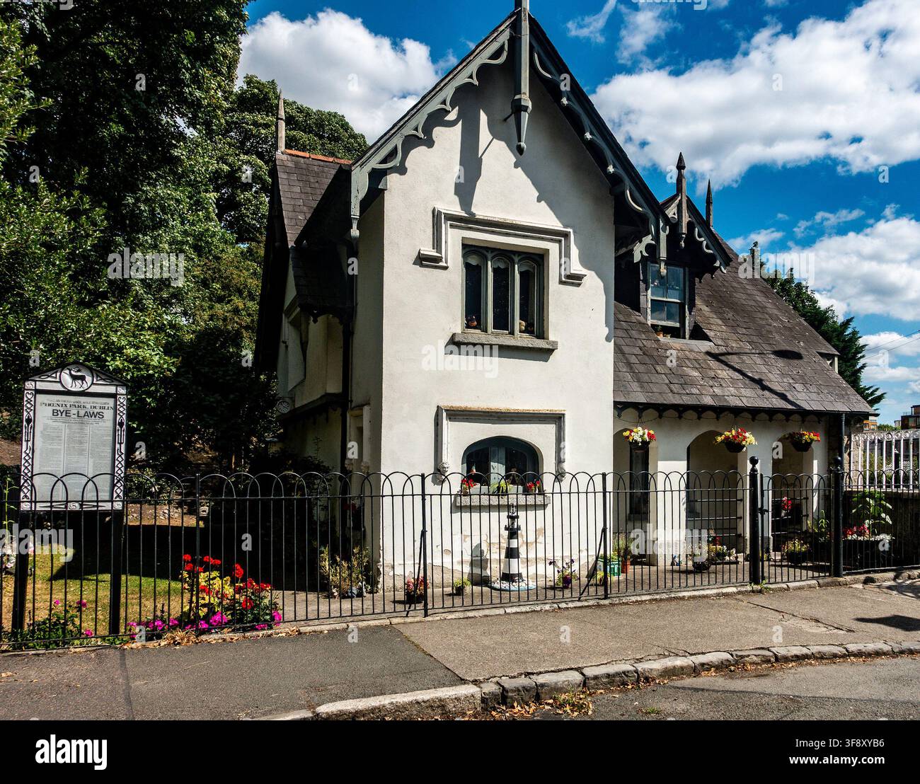 Die historische Gate Lodge am Islandbridge-Ausgang des Phoenix Park in Dublin hat weiße Wände, kunstvolle Zierleisten und einen schwarzen Zaun. Stockfoto