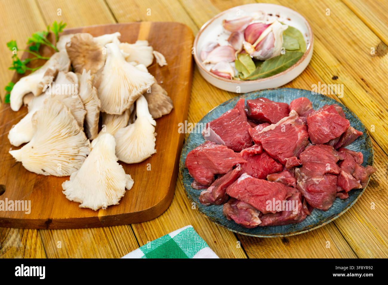 Rohe Kalbfleischstücke, Gewürze und Austernpilze. Stockfoto