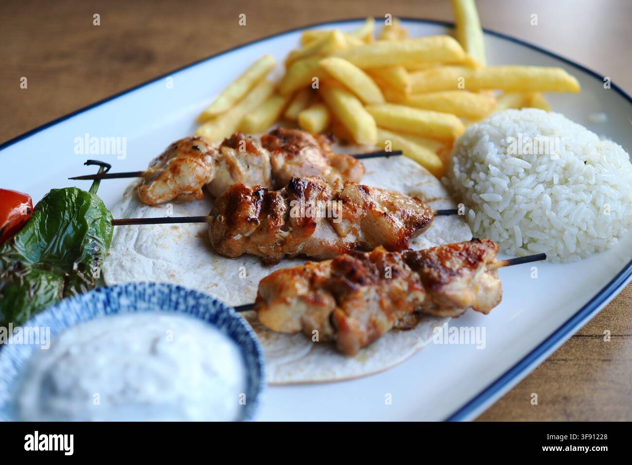 Gegrillte Hähnchenspieße mit Reis und Pommes frites Stockfoto