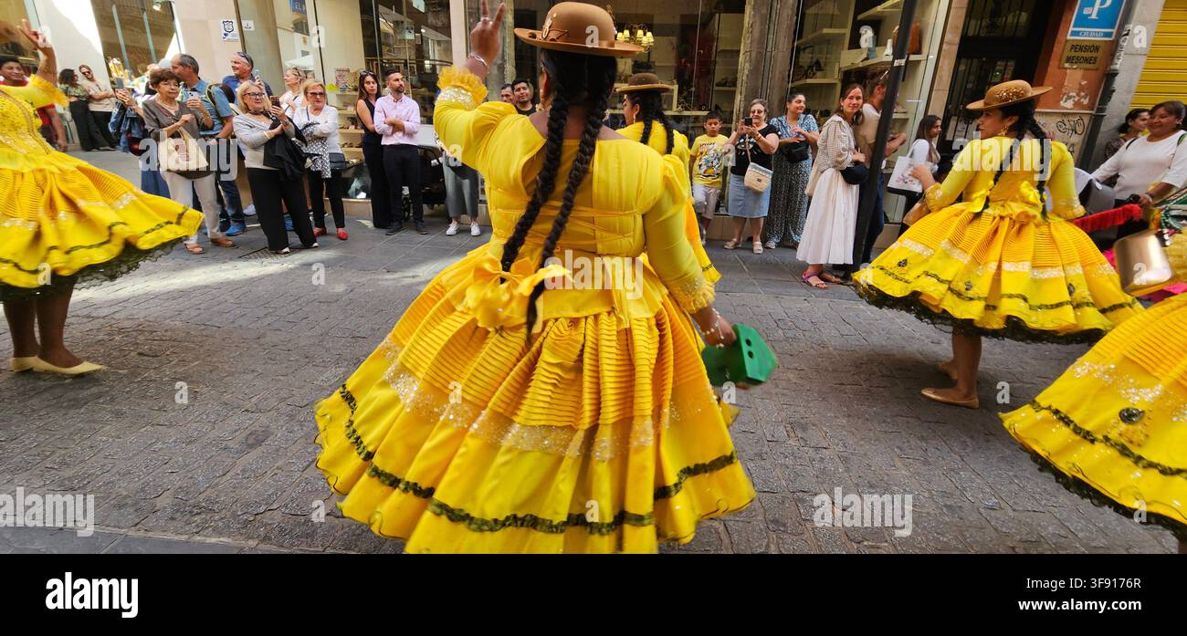 Frauen in gelben traditionellen Kostümen tanzen vor Zuschauern bei der Hispanidad-Parade in Granada, Spanien, am 12. OKT 2025. Stockfoto