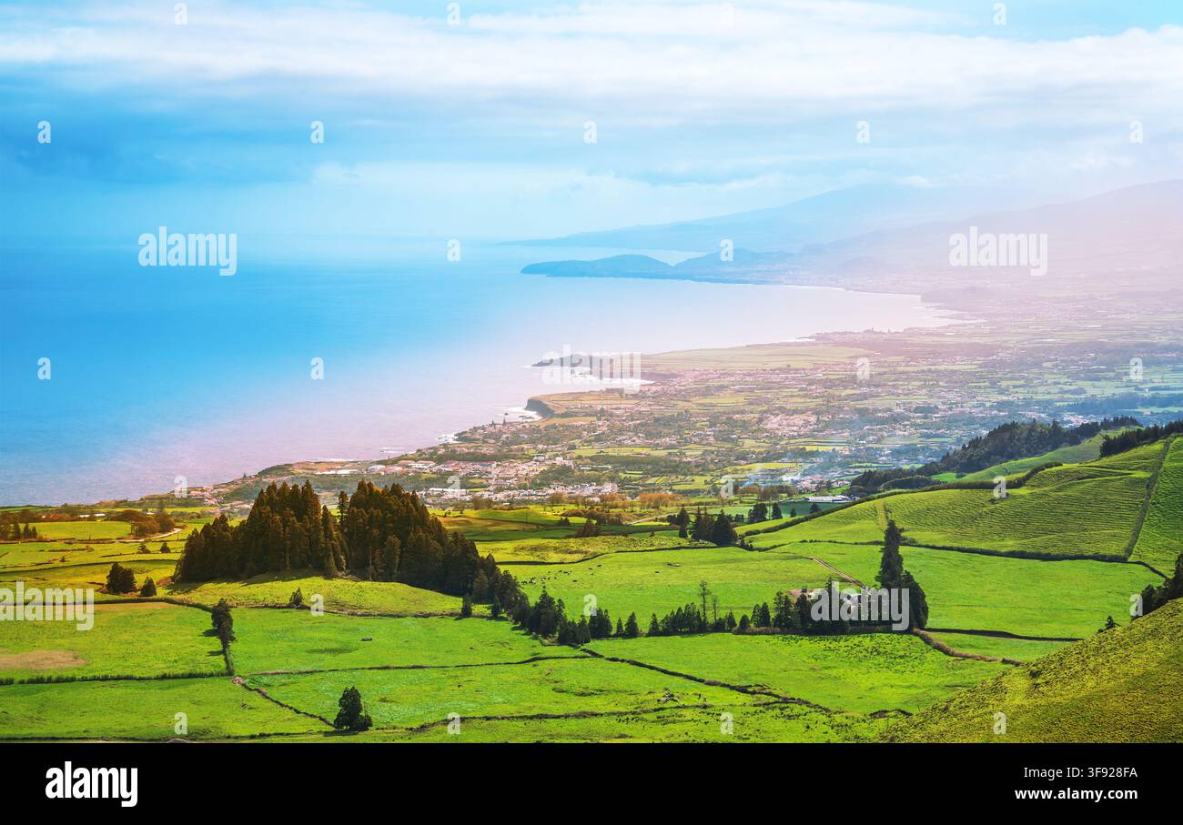 Luftaufnahme aus großer Höhe von üppigen grünen Weideflächen entlang der Küste mit Blick auf den Atlantischen Ozean und die Berge auf São Miguel, Azoren, Por Stockfoto
