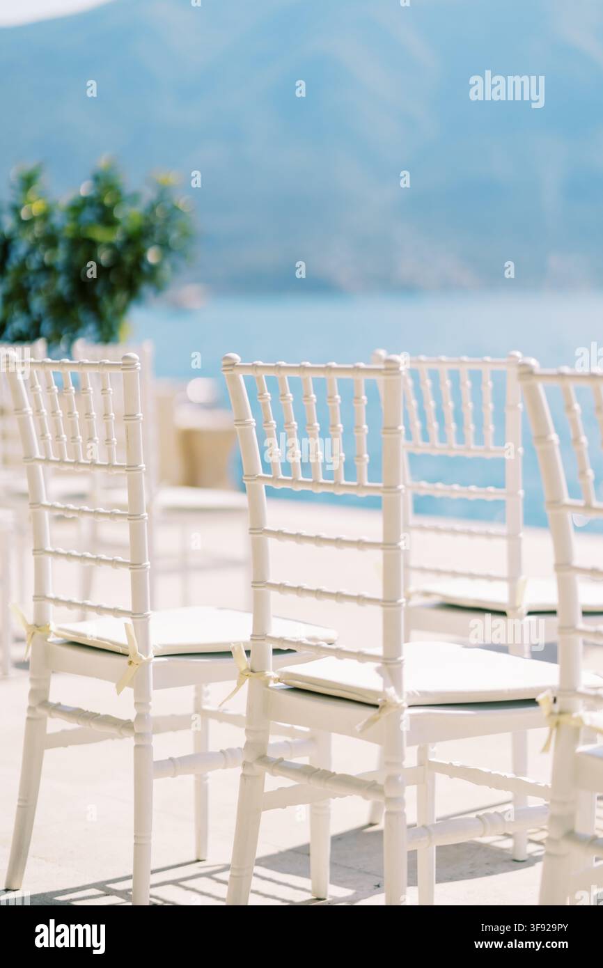 Weiße Hochstuhlstühle im Freien am Meer aufgestellt Stockfoto