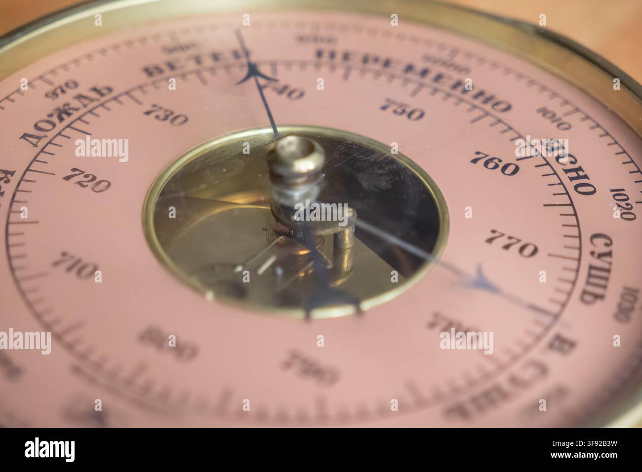 Ein antikes Aneroid-Barometer verfügt über einen goldenen Rahmen und kunstvolle mechanische Nadelanzeiger, die präzise Wetterbeobachtung und Wissenschaft symbolisieren Stockfoto