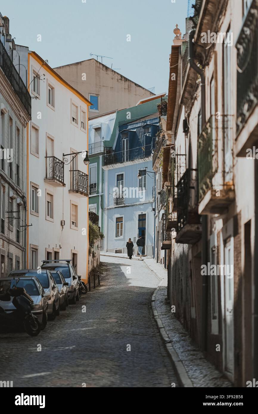 Menschen gehen eine schmale Kopfsteinpflasterstraße in Lissabon hinauf Stockfoto