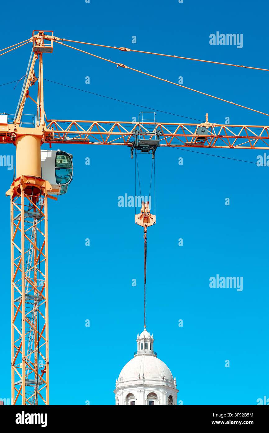 Gelber Baukran über einer historischen weißen Kuppel Stockfoto
