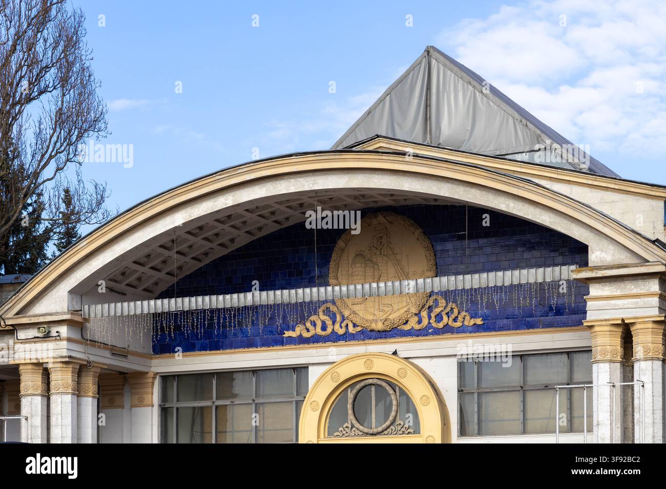 Kiew, Ukraine – 22. März 2026: Historische neoklassizistische Struktur zeigt traditionelle Reliefmauerarbeit an einer tiefblauen Keramikwand unter einem Schwan Stockfoto