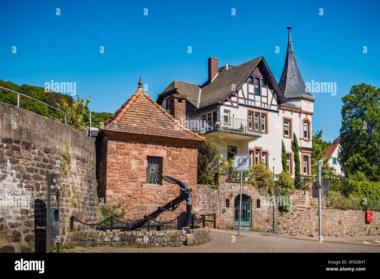 Neckarsteinach, Deutschland – 30. April 2026: Historische deutsche Uferarchitektur mit Steinmauern und einem markanten Anker am Rhein in Neckarsteinach Stockfoto
