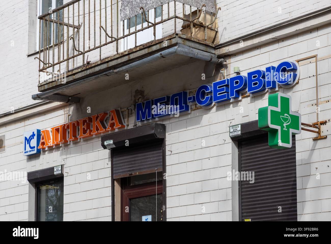 Kiew, Ukraine - 22. März 2026: Med-Service-Apothekenfassade mit einem auffälligen grünen medizinischen Kreuz und kräftiger Beschriftung an einer urbanen Wand repräsentiert den Zugang zu Stockfoto