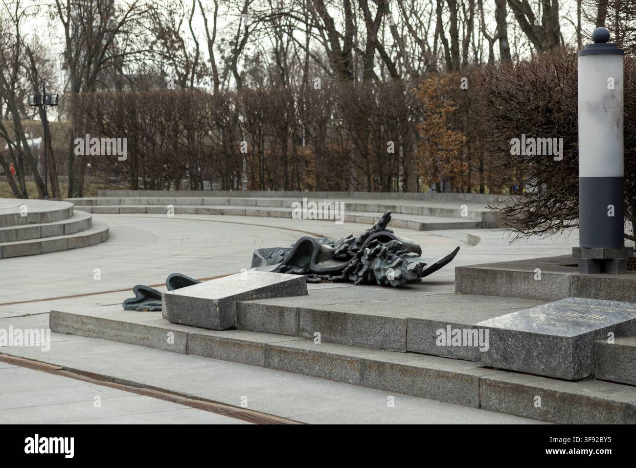 Kiew, Ukraine – 22. März 2026: Ein umgestürztes Metalldenkmal liegt auf einem gepflasterten Platz und symbolisiert die Entfernung oder den Zusammenbruch politischer Regime inmitten de Stockfoto