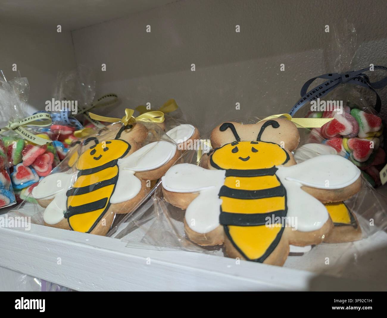 Handverzierte Hummelsüßkuchen, verpackt in klaren Zellophantüten auf einem Bäckereiregal, in Manhattan, New York, USA. - Smartphone-aufgenommenes Stockfoto