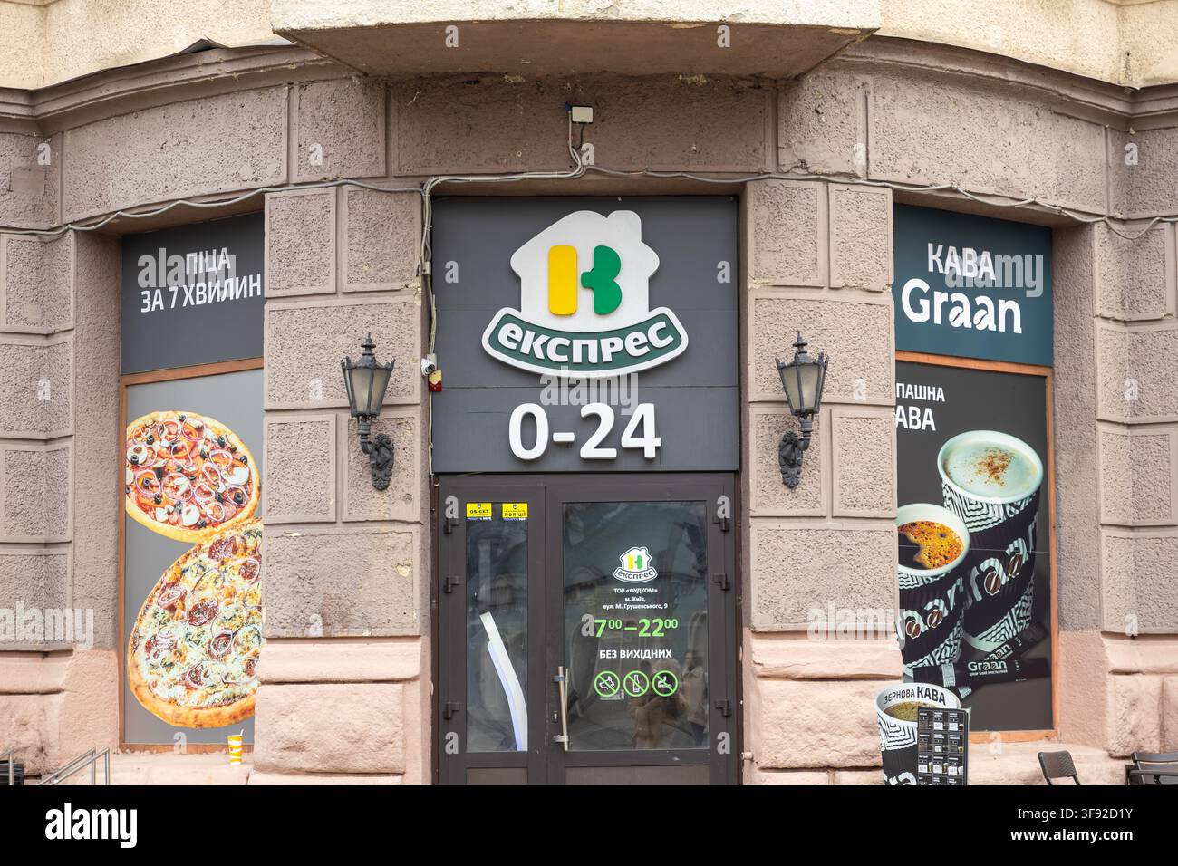 Kiew, Ukraine - 22. März 2026: Fassade eines Ekspres-Shops mit Pizzagraphiken und Kaffeemarketing auf den Fenstern, der einen 24-Stunden-Service in einer städtischen Umgebung anbietet Stockfoto