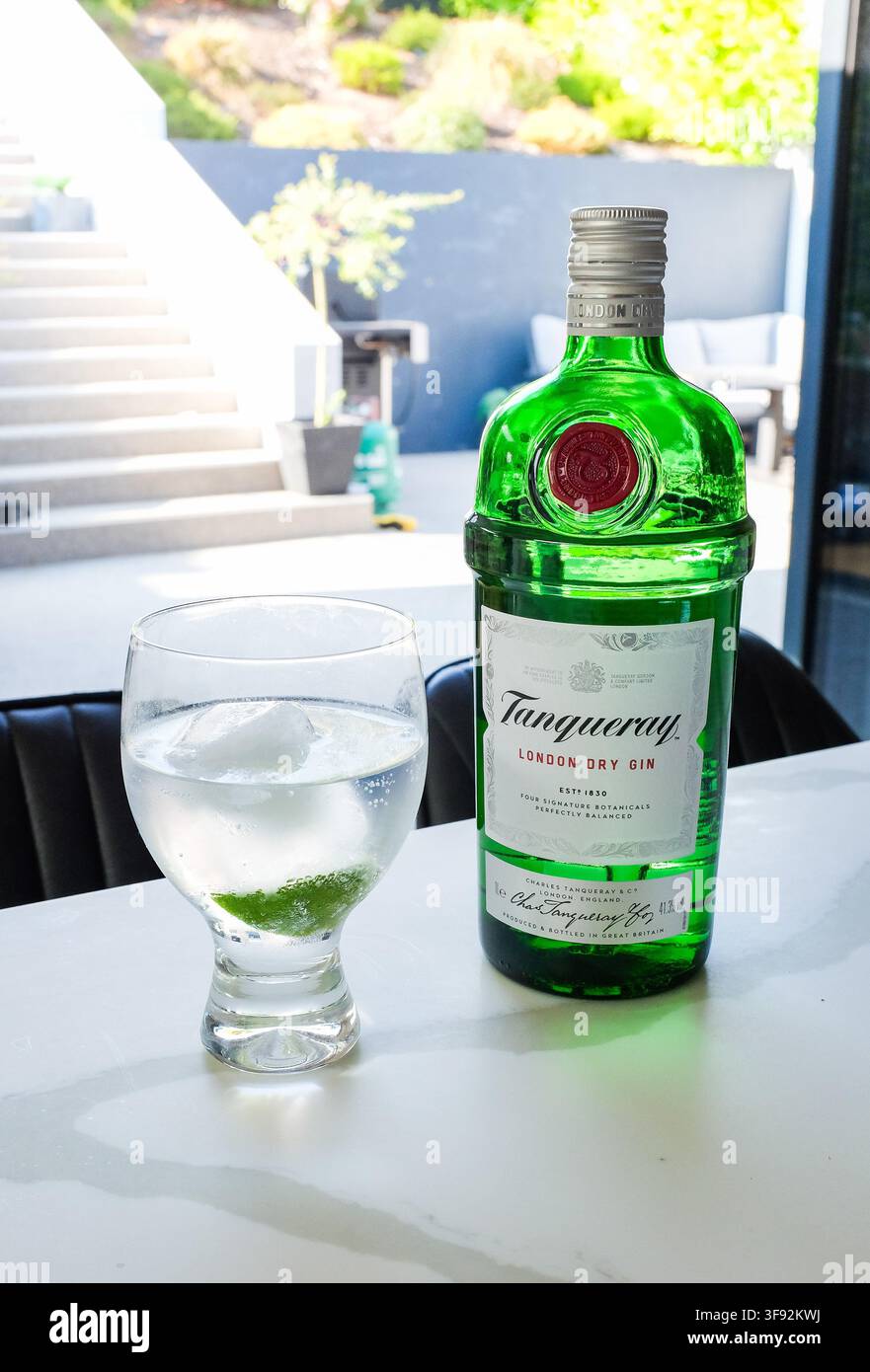 Glas und Flasche Tanqueray Gin & Tonic mit Eis und Limettenscheibe Sommergetränk 2026 Stockfoto