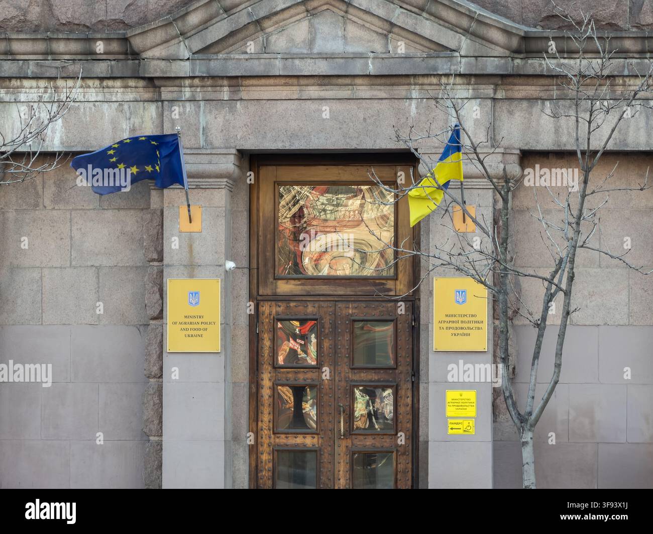 Kiew, Ukraine - 15. März 2026: Die Flaggen der Europäischen Union und der Ukraine, die am Eingang des Regierungsministeriums aufgehängt sind, symbolisieren diplomatische Ausrichtung und offi Stockfoto