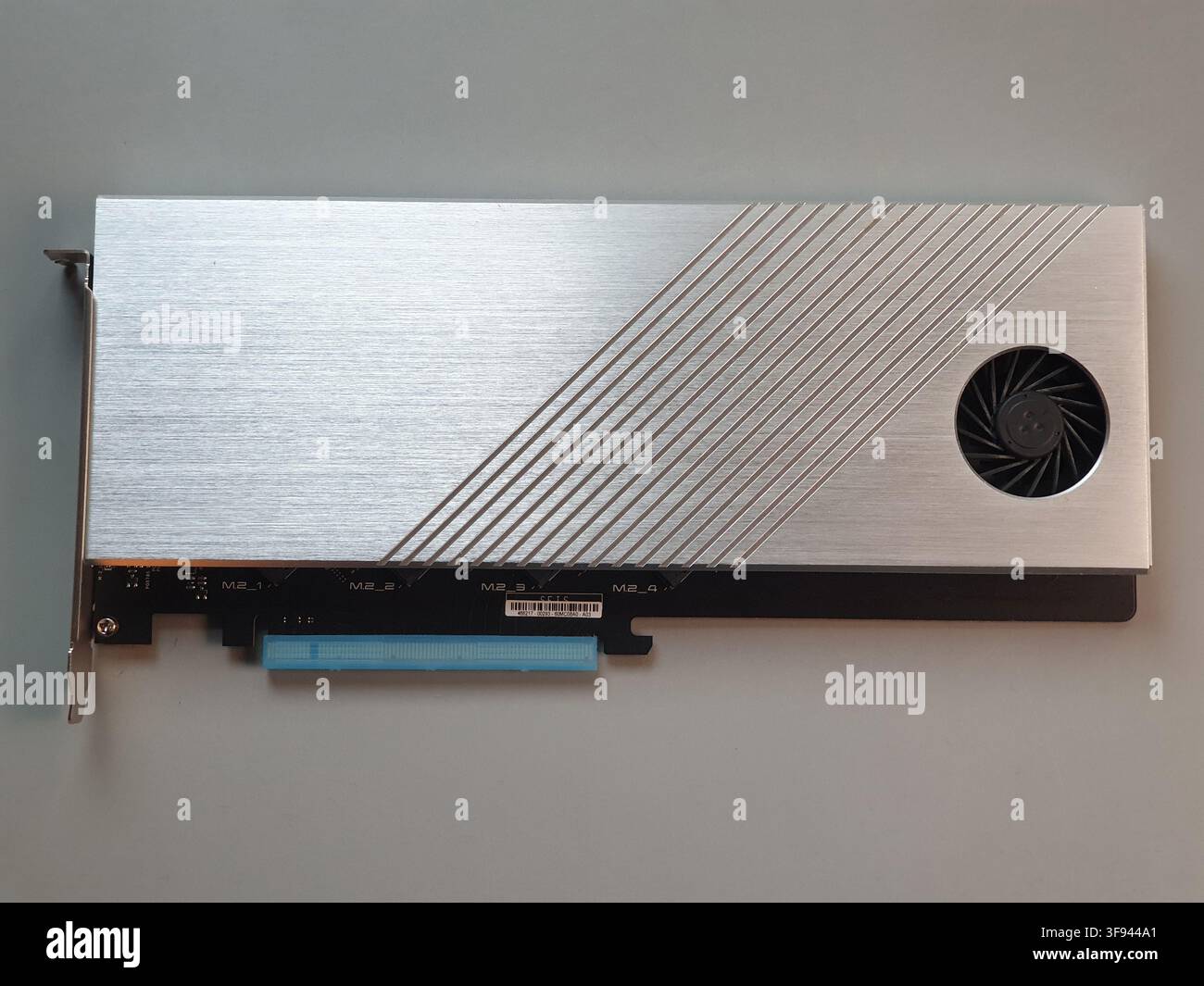 Eine silberne M2 NVMe SSD-Erweiterungskarte wird auf einem grauen Hintergrund gezeigt Stockfoto