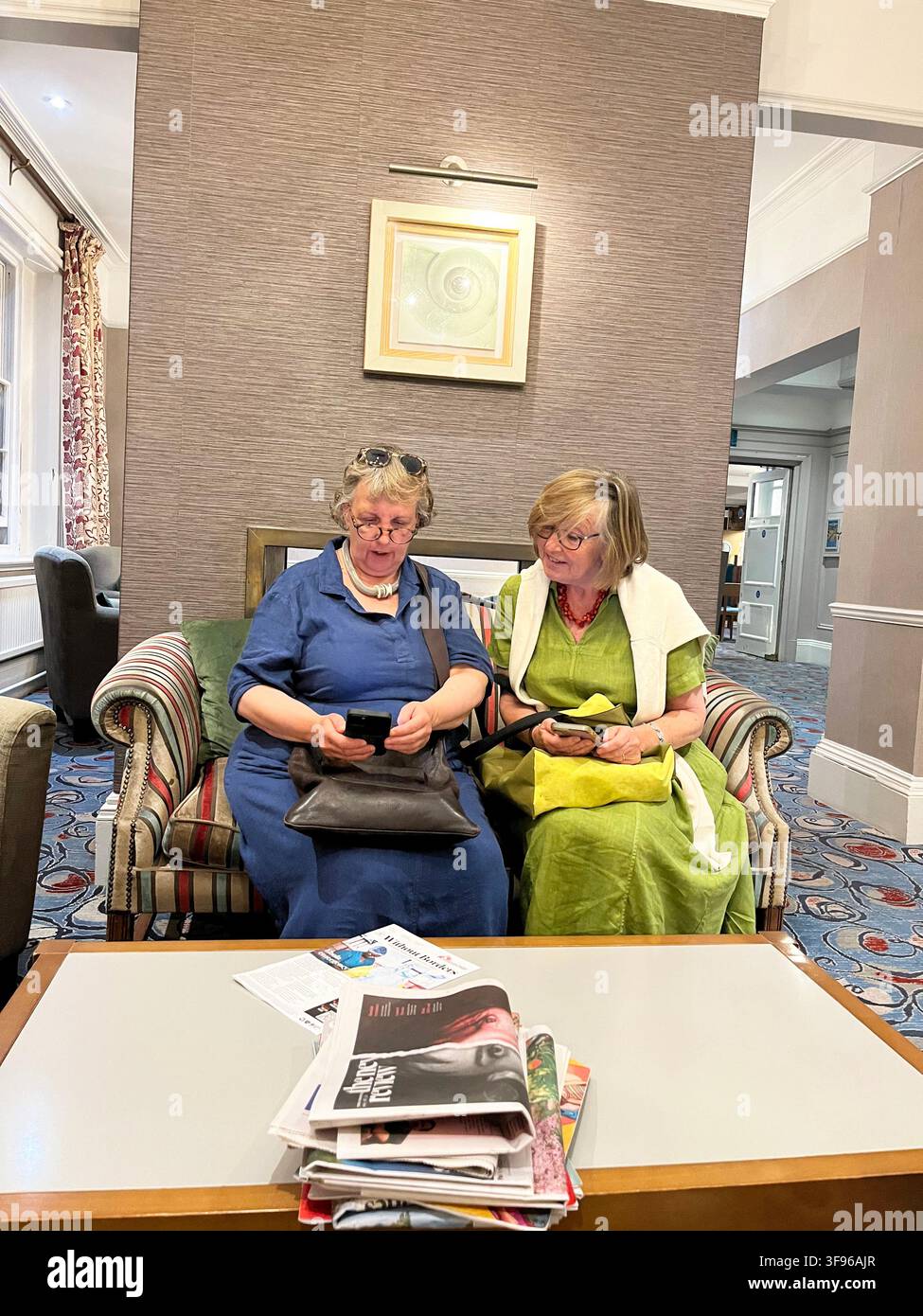 Zwei alte Damen mit Mobiltelefonen im The White Lion Hotel, Aldeburgh Suffolk P15 5BJ Vereinigtes Königreich Stockfoto
