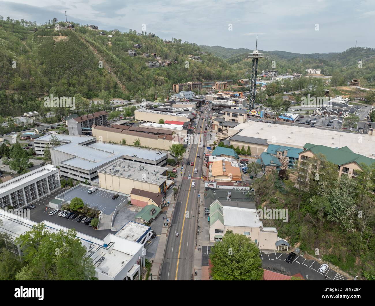 Luftbild der Gatlinburg Space Needle, die über der Hauptstraße aufragt, umgeben von Hotels, Parkplätzen und üppigen bewaldeten Hügeln in Gatlinburg, Te Stockfoto