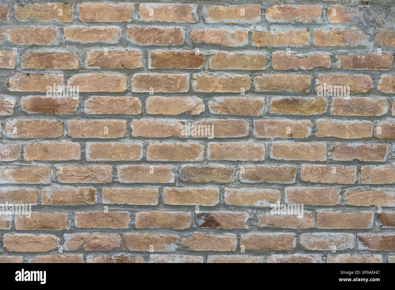 Traditioneller Ziegelmauer-Hintergrund mit gealterten Ziegeln und glattem Mörtel Stockfoto