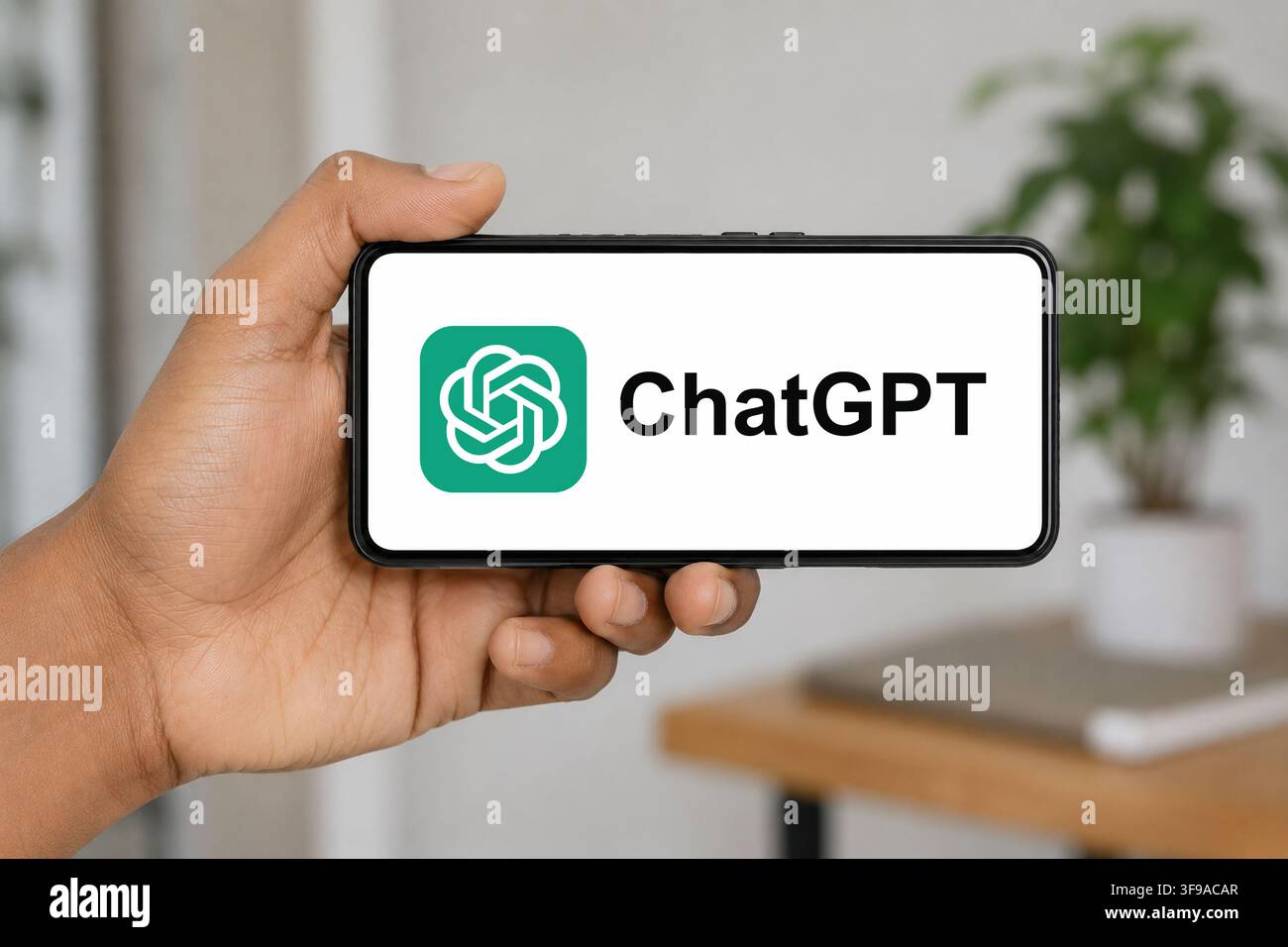 15. August 2026: In dieser Fotoillustration hält eine Hand ein Smartphone horizontal, das das ChatGPT-KI-Logo anzeigt, vor einem sanft verschwommenen Innenhintergrund, in Indien am 15. August 2026. (Bildnachweis: © David Talukdar/ZUMA Press Wire) NUR FÜR REDAKTIONELLEN GEBRAUCH! Nicht für kommerzielle VERWENDUNG! Stockfoto