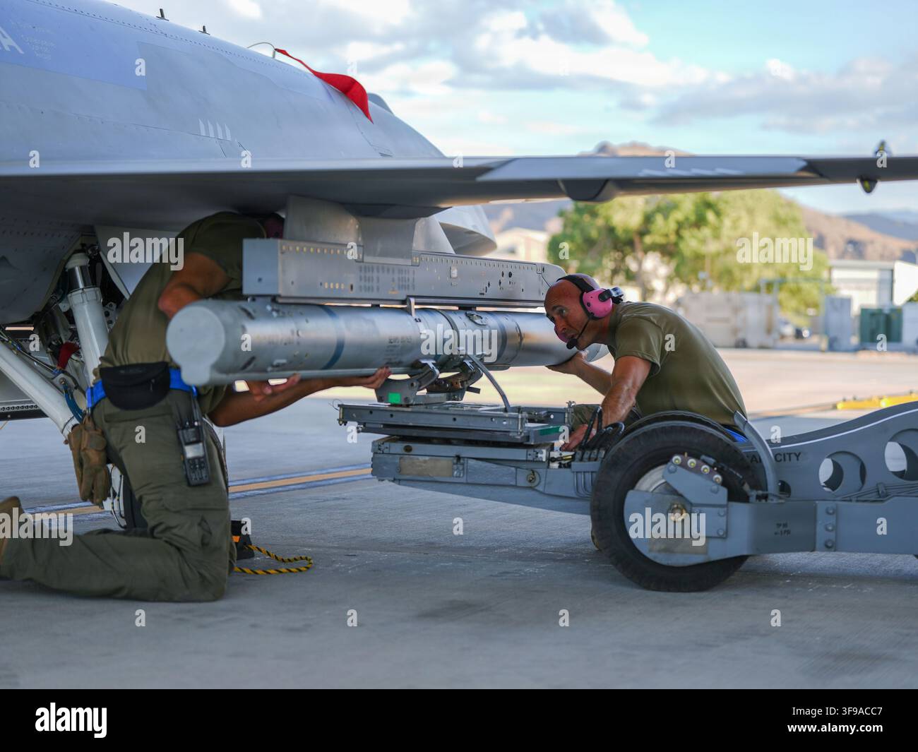 U.S. Airmen, die der Collaborative Combat Aircraft Experimental Operations Unit zugeteilt sind, richten eine Innert-Rakete auf ein YFQ-44A Fury-Flugzeug bei Creech Ai aus Stockfoto