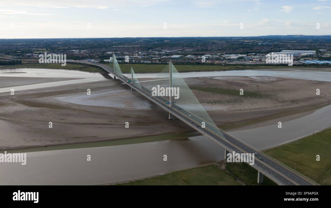 Luftaufnahme der Mersey Gateway Bridge, die den Fluss Mersey überspannt, mit Schlickflächen bei Ebbe und der Stadt Runcorn im Hintergrund, Runcorn, Unite Stockfoto