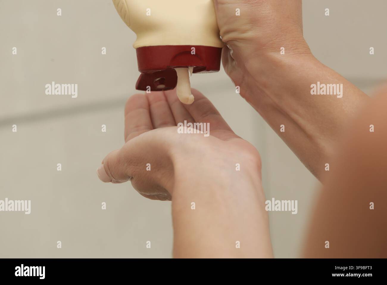 Nahaufnahme vom Ausdrücken von Haarspülung auf die Handfläche Stockfoto