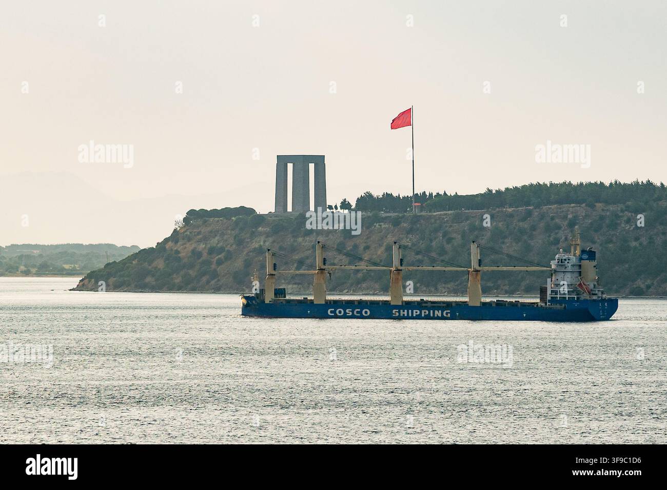 Ein Tanker vor Canakkale Sehitler Abidesi an der Einfahrt zur Strasse der Dardanellen, ein riesiger Bogen, der an die gefallenen Soldaten der Schlacht erinnert Stockfoto