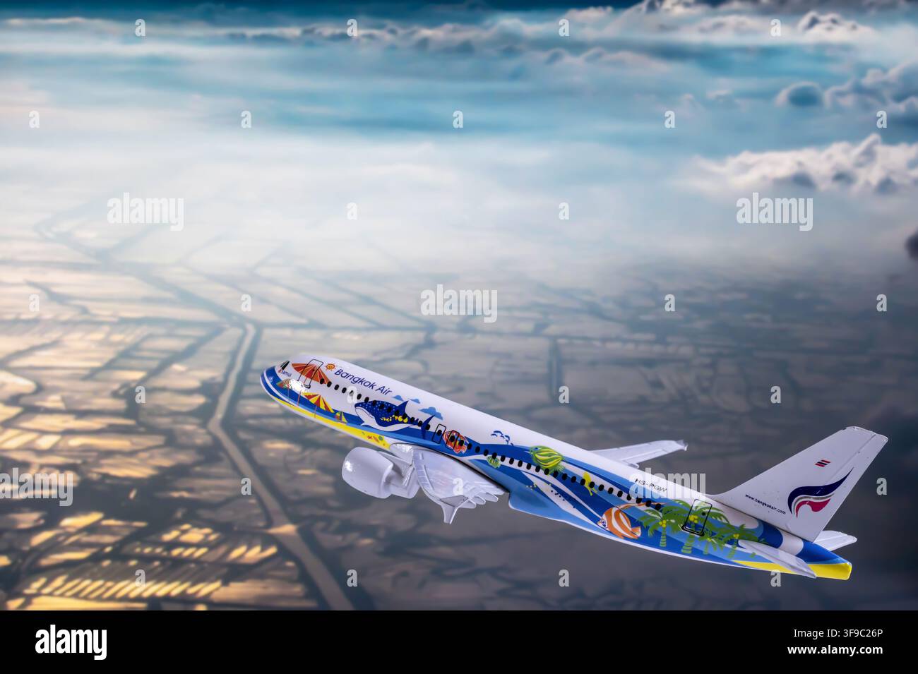 Chiang Mai, Thailand - 07. August 2026 : Bangkok Airways Samui Walhaaien-Lackierung-Modellflugzeug über bewölkten Luftfarmland Stockfoto