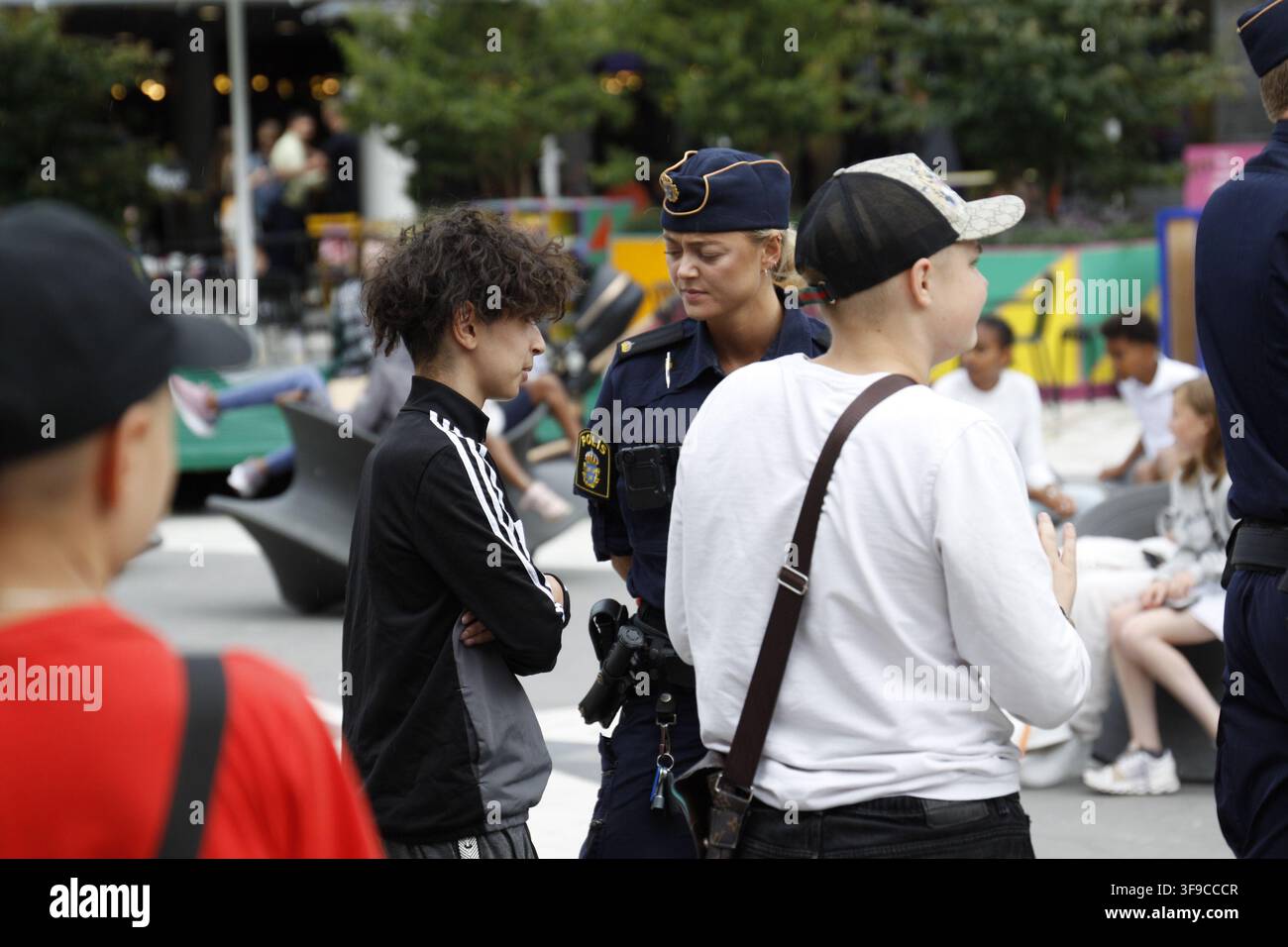 Blonde schwedische Polizeibeamtin befragt einen Mann am Sergels torg, Drottninggatan, Stockholm, Schweden. Stockfoto