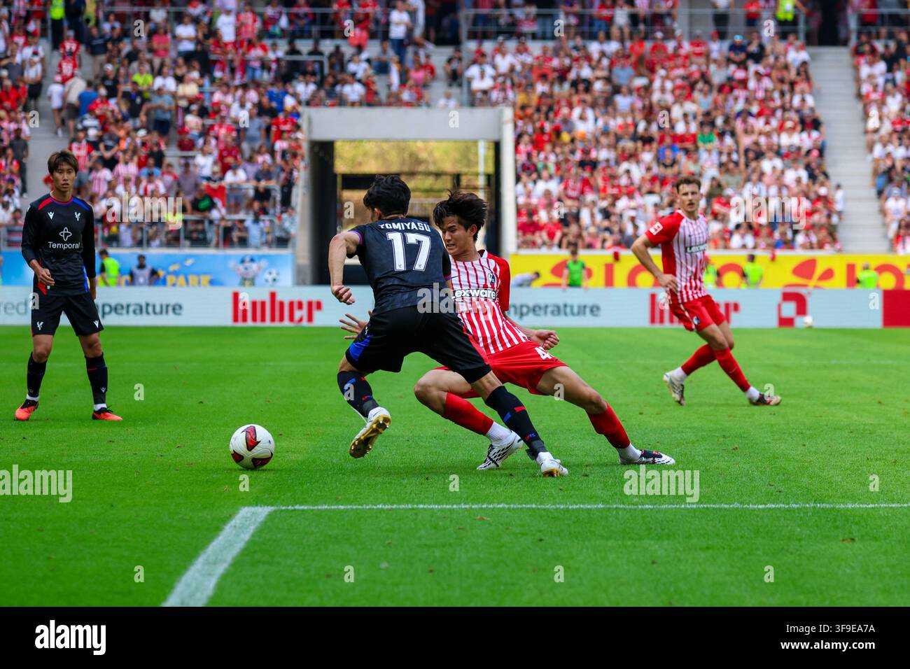 Freiburg, Deutschland, 15. August 2026: Testspiel [Testspiel] - 2026/2027 - Freiburg gegen Crystal Palace Im Bild: von links. im Duell Takehiro Tomiyasu (CRY) und Keisuke Goto (SCF) /// DFL / DFB-Vorschriften verbieten jede Nutzung von Fotos als i Stockfoto
