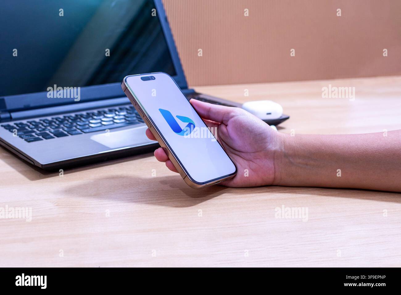 Hand, die ein iPhone mit dem Bing-App-Logo hält. Stockfoto