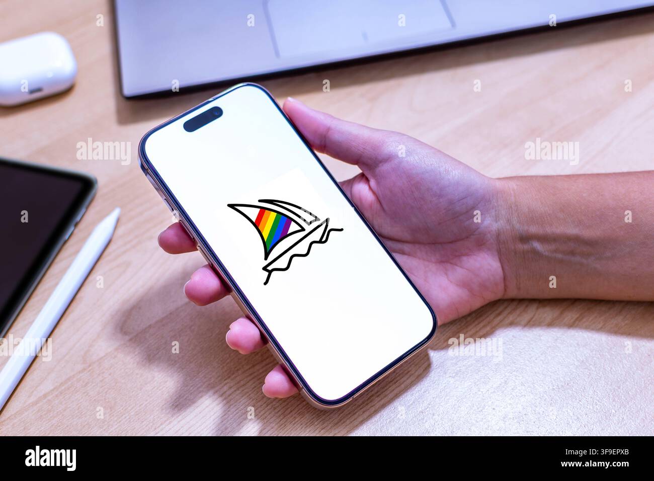 Hand, die ein iPhone mit dem Midjourney-App-Logo hält. Stockfoto