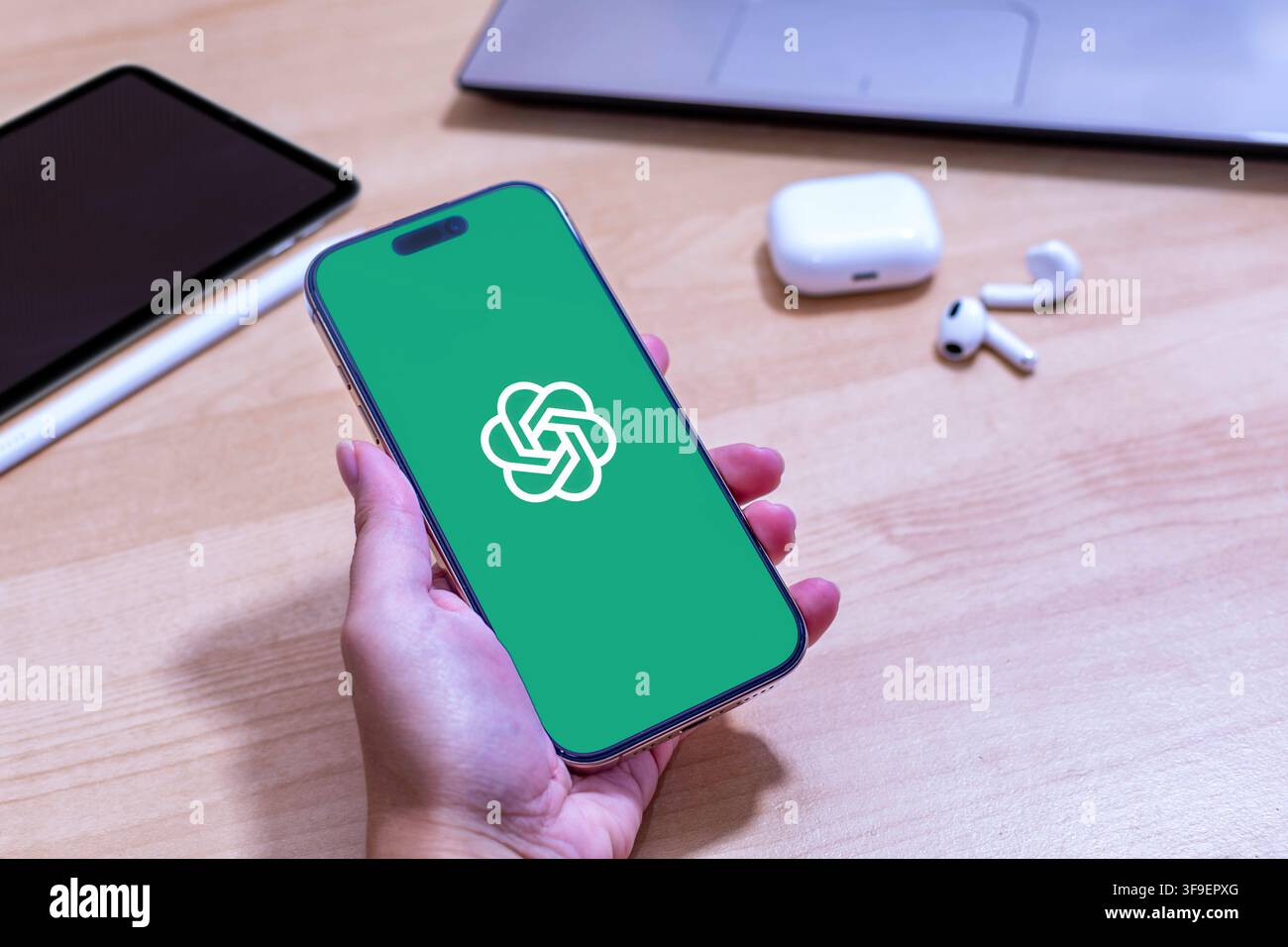 Hand, die ein iPhone mit dem Open AI-App-Logo hält. Stockfoto