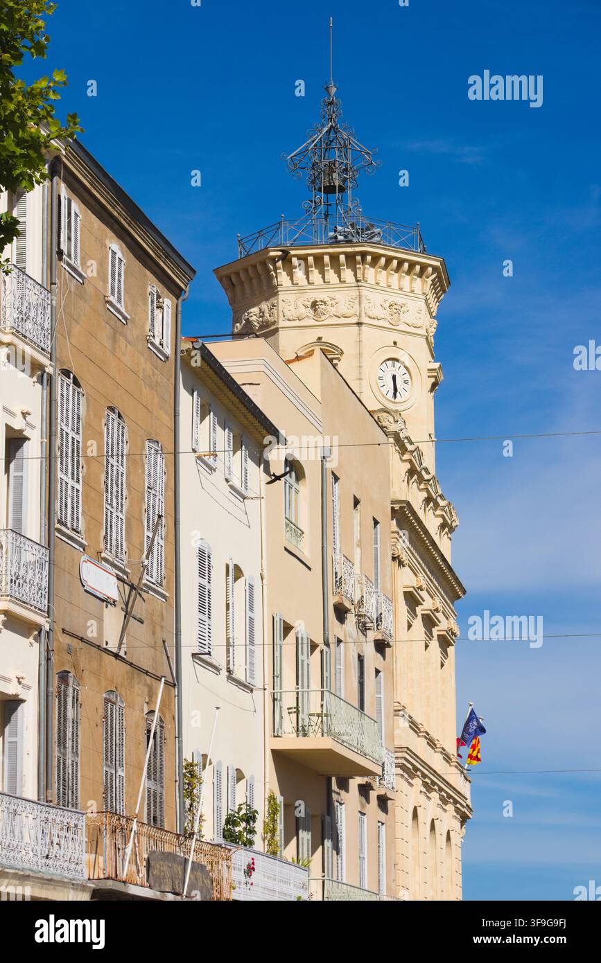 Historische Stadthäuser mit traditionellen Fensterläden und kunstvollem eisernem Uhrturm des Alten Rathauses in La Ciotat, französische Riviera, Frankreich. Stockfoto