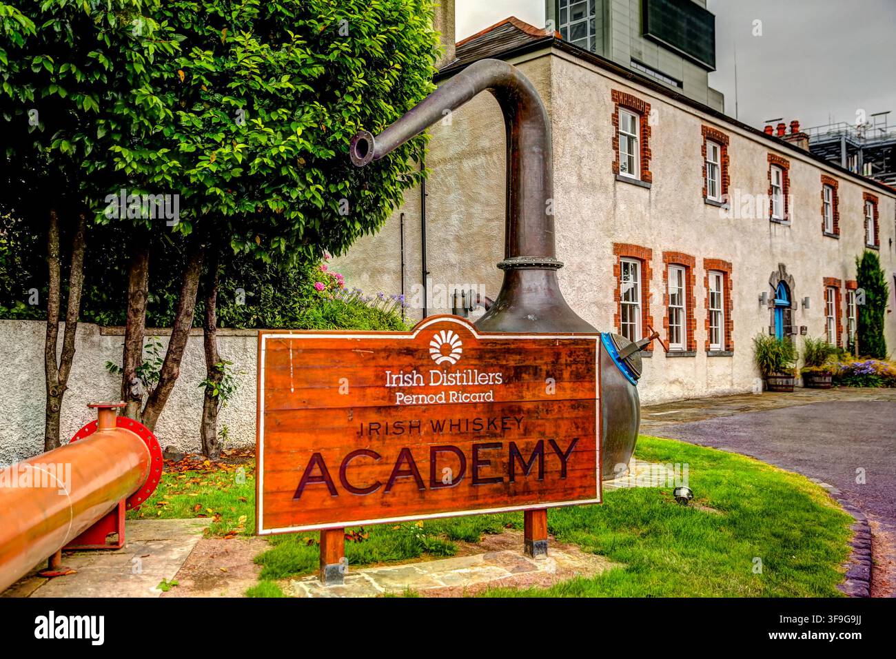 Das Schild der Irish Distillers Academy steht vor einem historischen Gebäude der Old Midleton Distillery in der Grafschaft Cork. Stockfoto