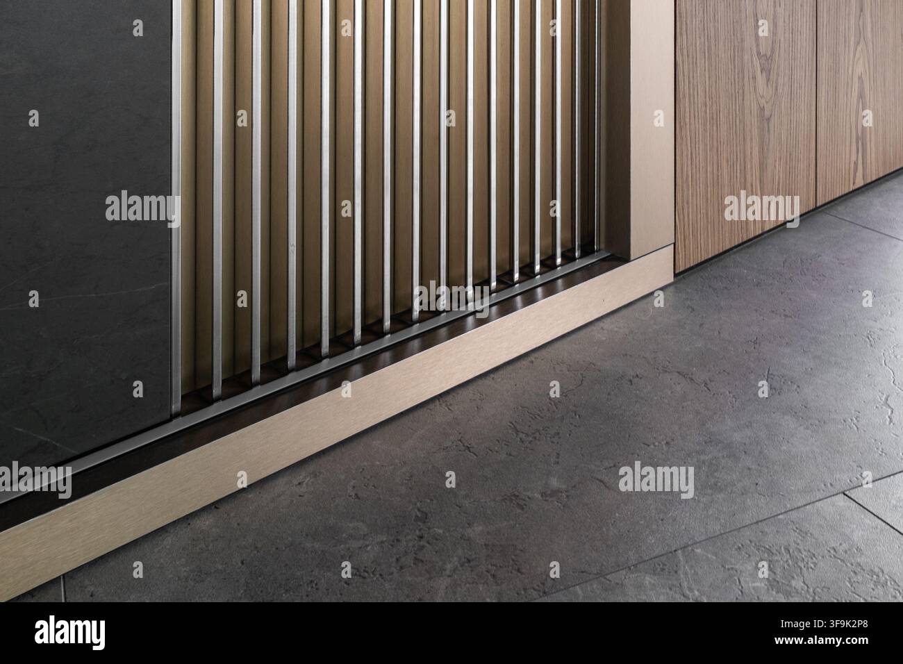 Modernes minimalistisches Innendetail mit vertikalen Holzlattenwandpaneelen, dunklen Steinoberflächen und gebürsteten Metallakzenten Stockfoto