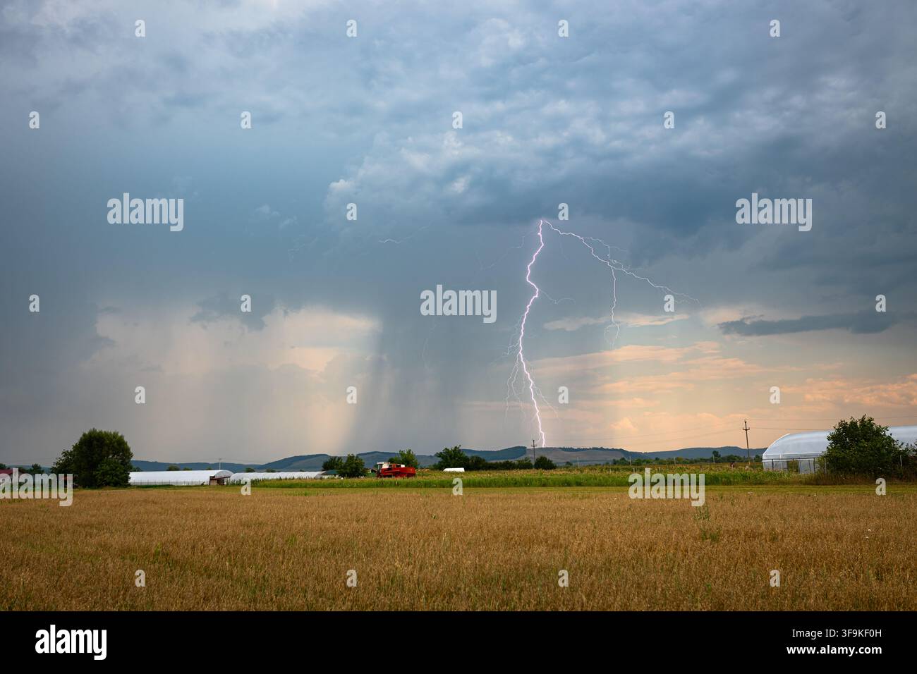 Dramatischer Blitzschlag am Tag mit dunklen Wolken und Regenschauer Stockfoto