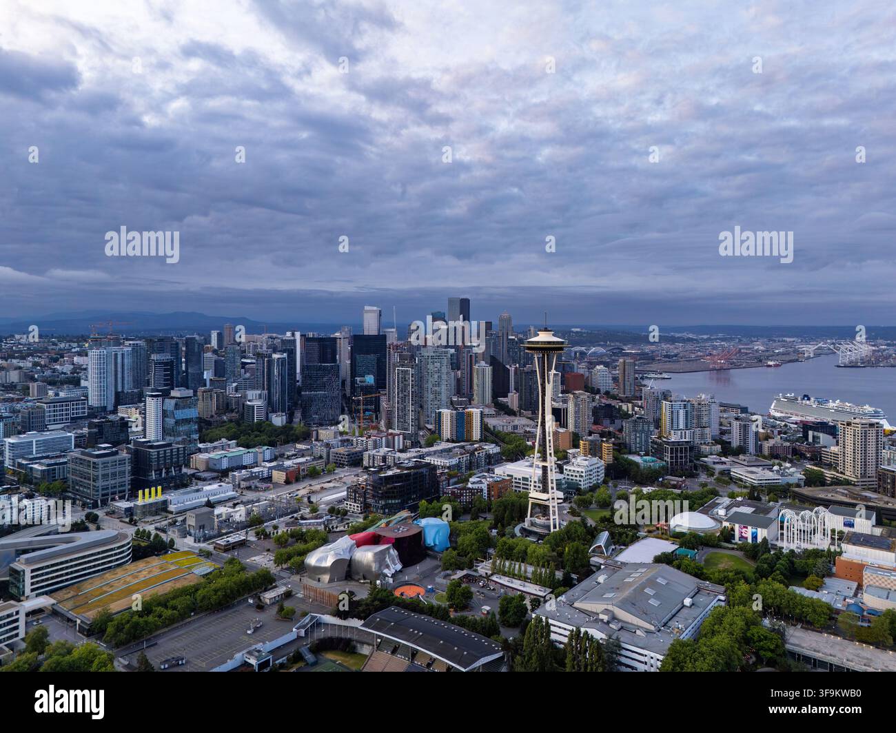 Blick auf die Space Needle und die Skyline von Seattle mit modernen Wolkenkratzern, Uferpromenade und bewölktem Himmel, Seattle, Washington, Vereinigte Staaten. Stockfoto