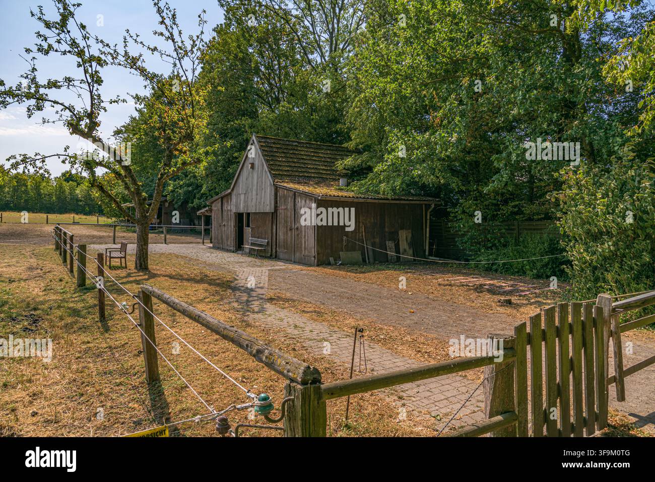 Alte Holzscheune und Weidezaun in einer ländlichen Bauernhofumgebung in Coesfeld, Deutschland Stockfoto