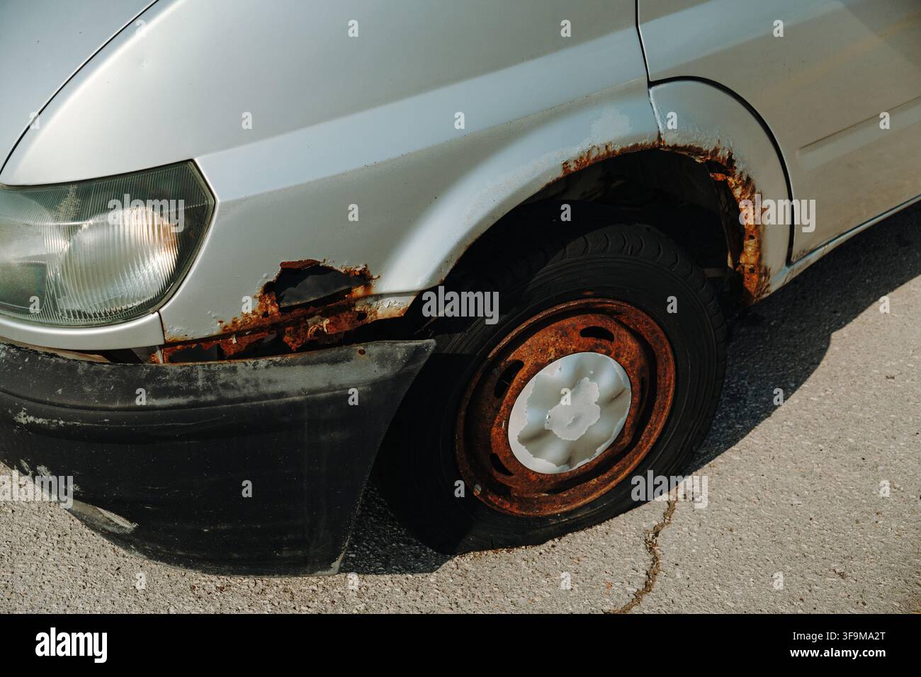 Alter Van hat starken Rost um den Radkasten und die Karosserieteile. Das Bild veranschaulicht Korrosion, Alterung, Fahrzeugschäden, Reparatur und Wartung. Stockfoto