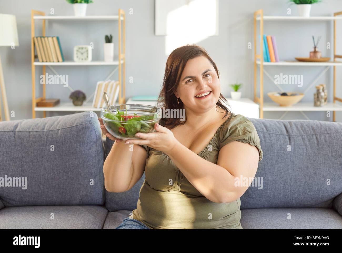 Glückliche abnehmende vegetarische Ernährung, essen von grünem Gemüse, Gemüsesalatmenü zum Abendessen, angenehm Stockfoto