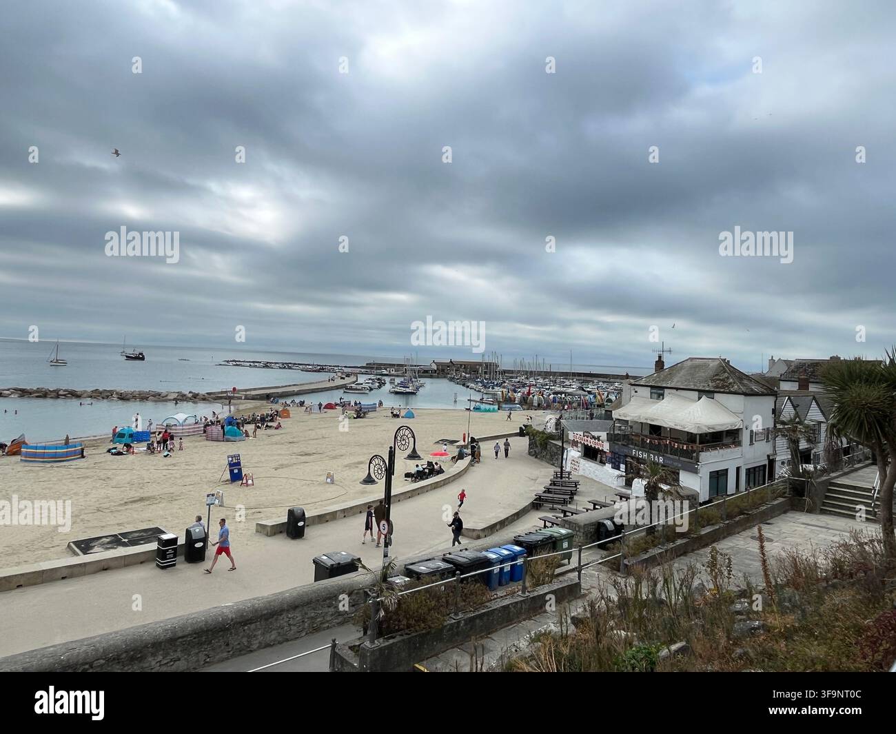 Blick über den Strand in Richtung Hafen von Lyme Regis, Dorset, England, UK. Stockfoto