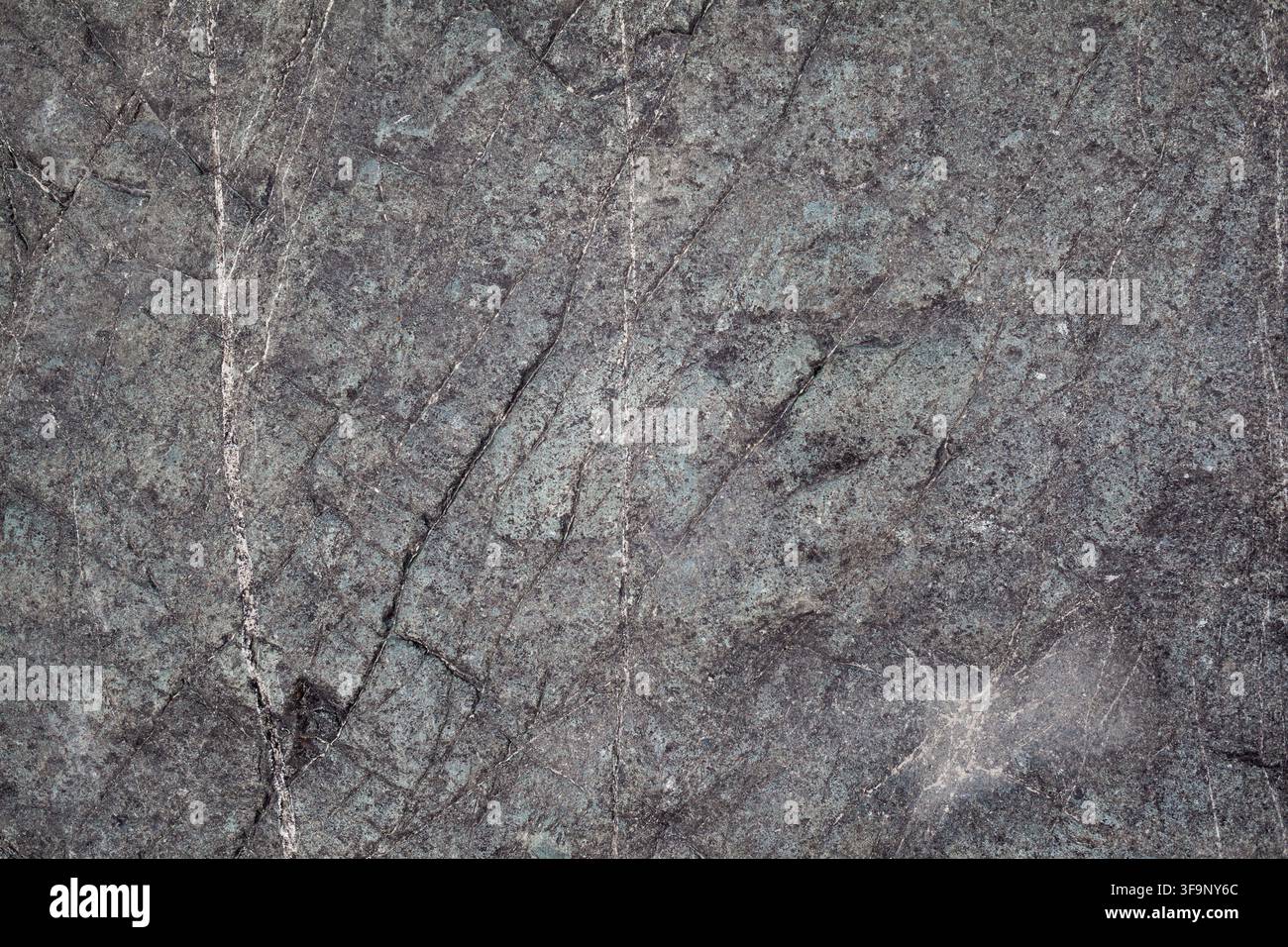Strukturierte dunkle Steinoberfläche mit natürlichen Mustern und Adern, geeignet für Hintergründe oder Designelemente in verschiedenen Anwendungen Stockfoto