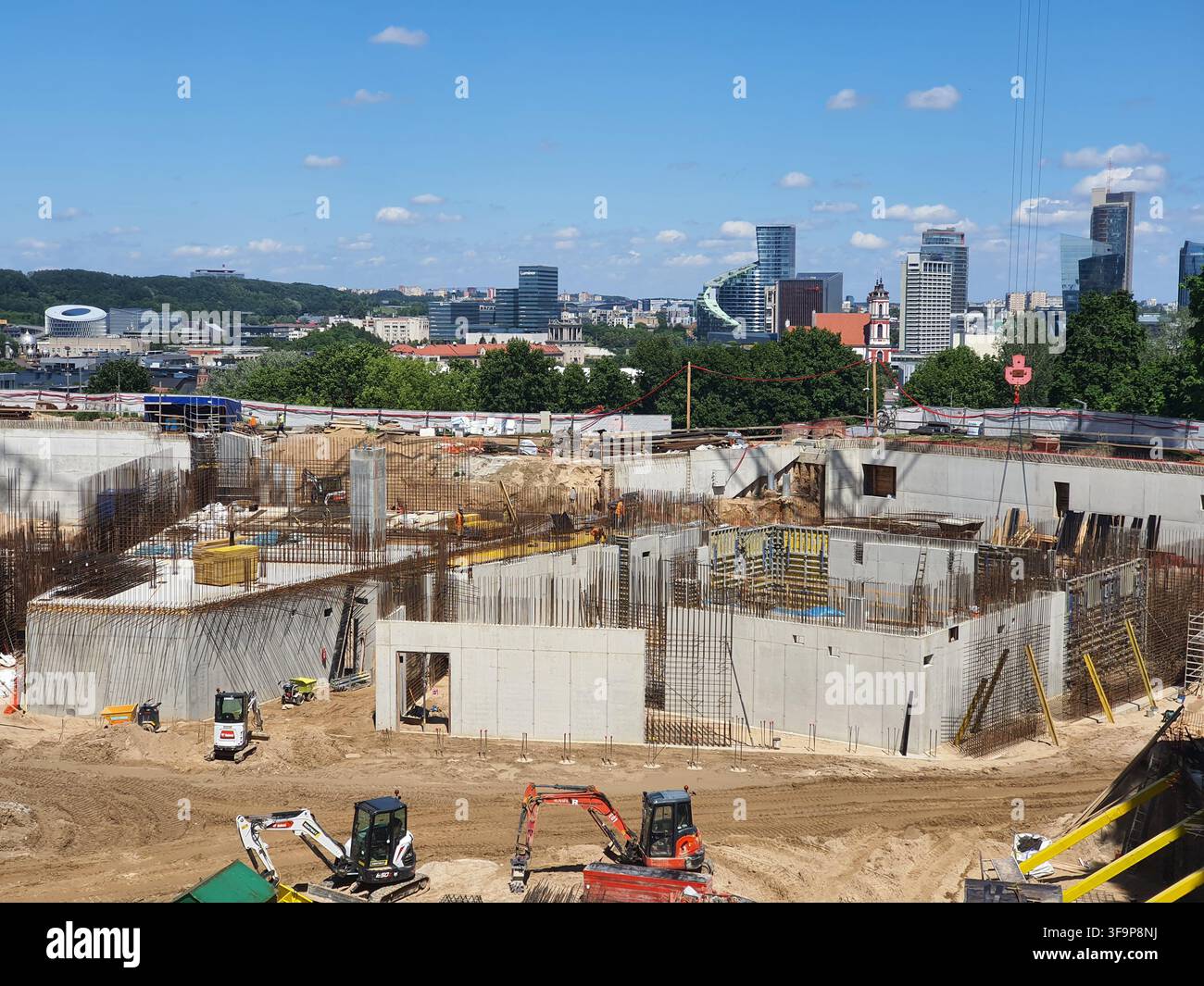 Eine Weitwinkelansicht einer großflächigen Baustelle in einem städtischen Gebiet, die die frühen Stadien der Fundamentarbeiten zeigt. Der Vordergrund zeigt Stockfoto