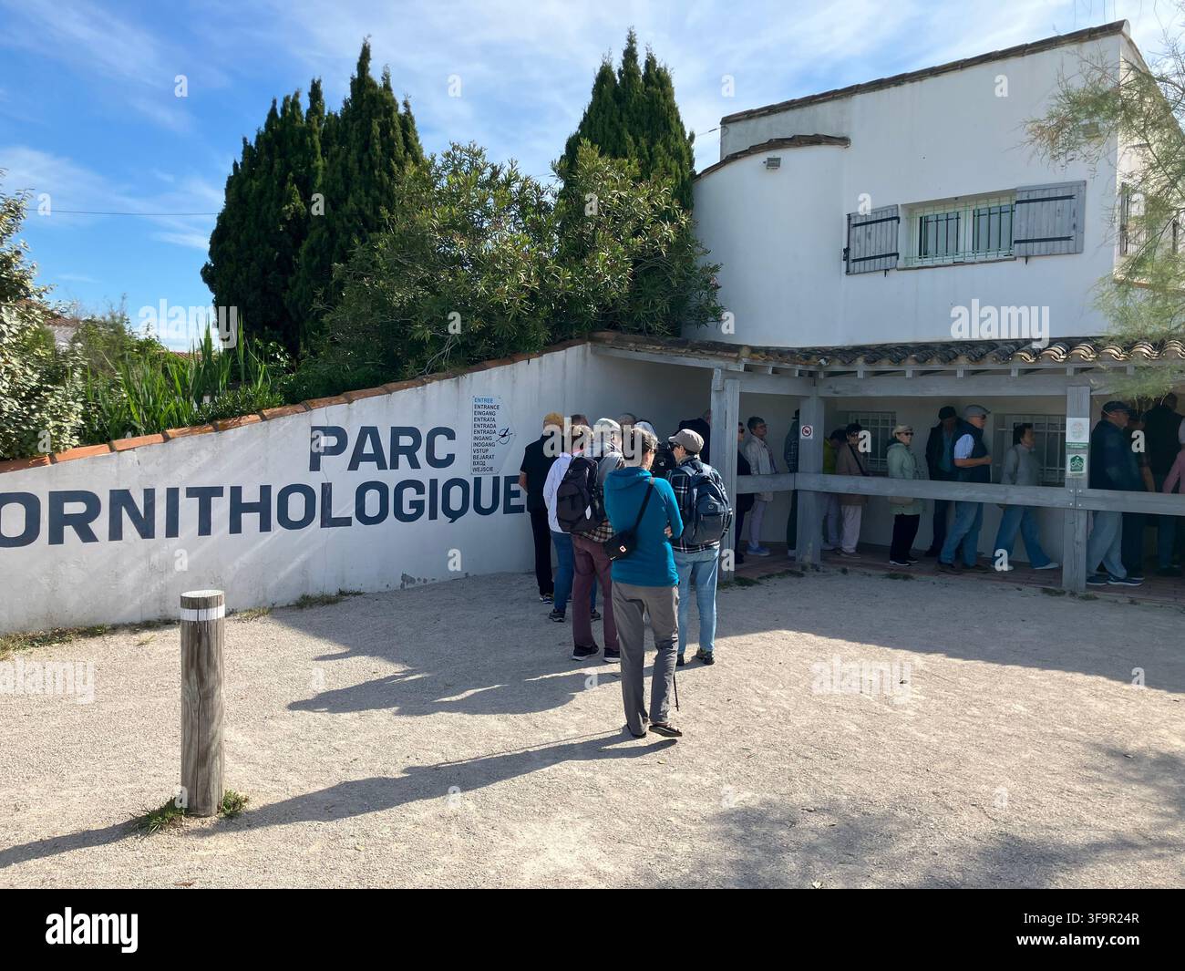 Besucher stehen am Eingang des Parc Ornithologique du Pont de Gau in Saintes-Maries-de-la-Mer, Camargue, Frankreich Schlange. - Smartphone-aufgenommenes Stockfoto