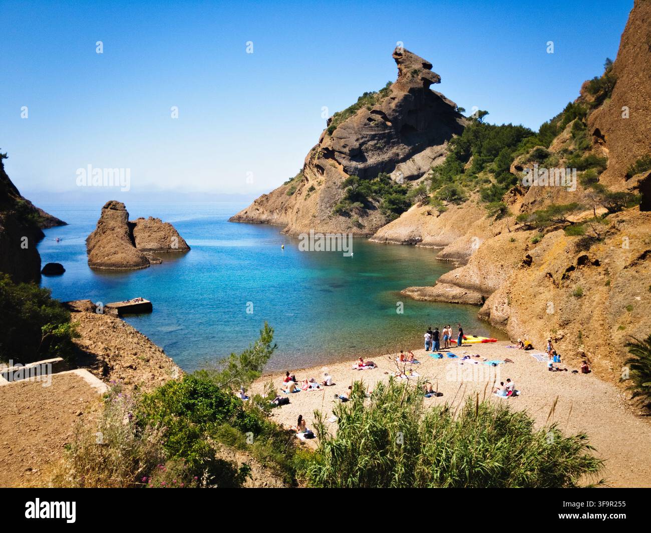 Strandbesucher entspannen sich an der Calanque de Figuerolles in der Nähe der ikonischen Felsformation Bec de l'Aigle in La Ciotat, Provence, Frankreich. Stockfoto
