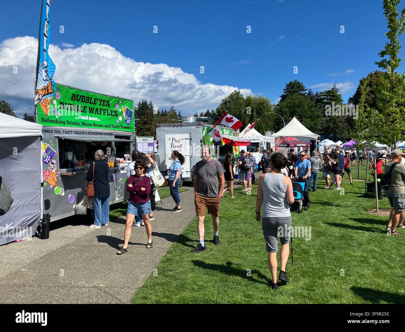 Menschen genießen das Nautical Days-Ereignis mit Foodtrucks und Händlern im Comox Marina Park an einem sonnigen Tag in Comox, British Columbia, Kanada. - Smartphone-aufgenommenes Stockfoto