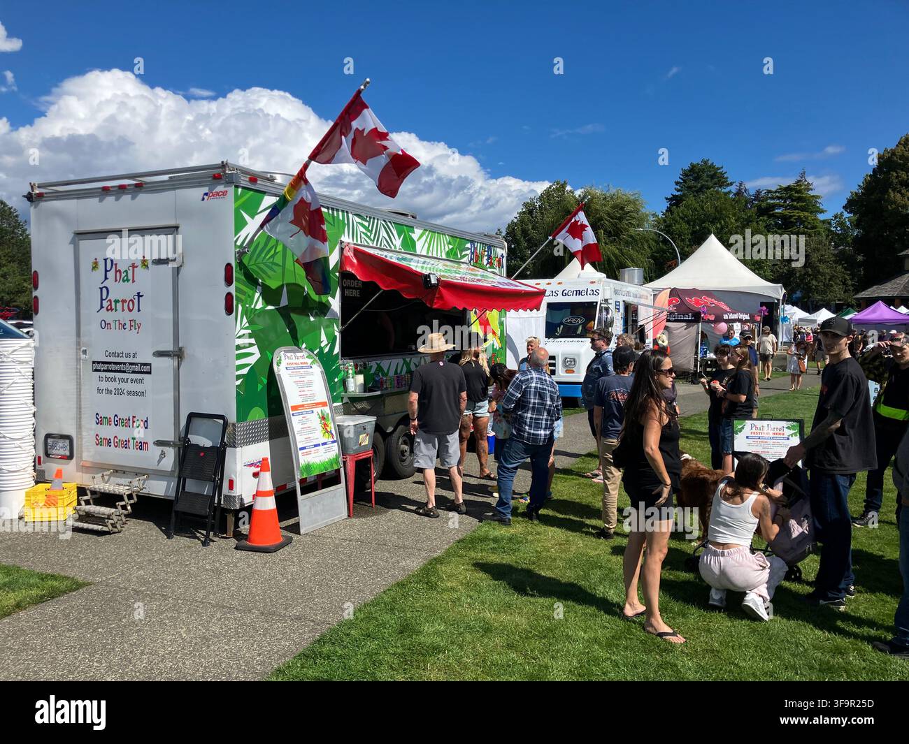 Menschen genießen das Nautical Days-Ereignis mit Foodtrucks und Händlern im Comox Marina Park an einem sonnigen Tag in Comox, British Columbia, Kanada. - Smartphone-aufgenommenes Stockfoto