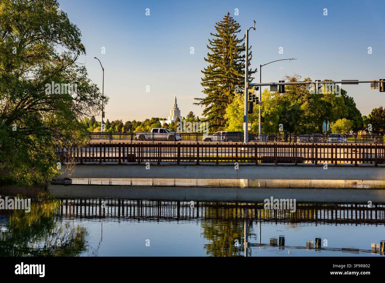 Scenische Brücke über den Snake River, die Bäume und den Idaho Falls Temple im Hintergrund reflektiert Stockfoto